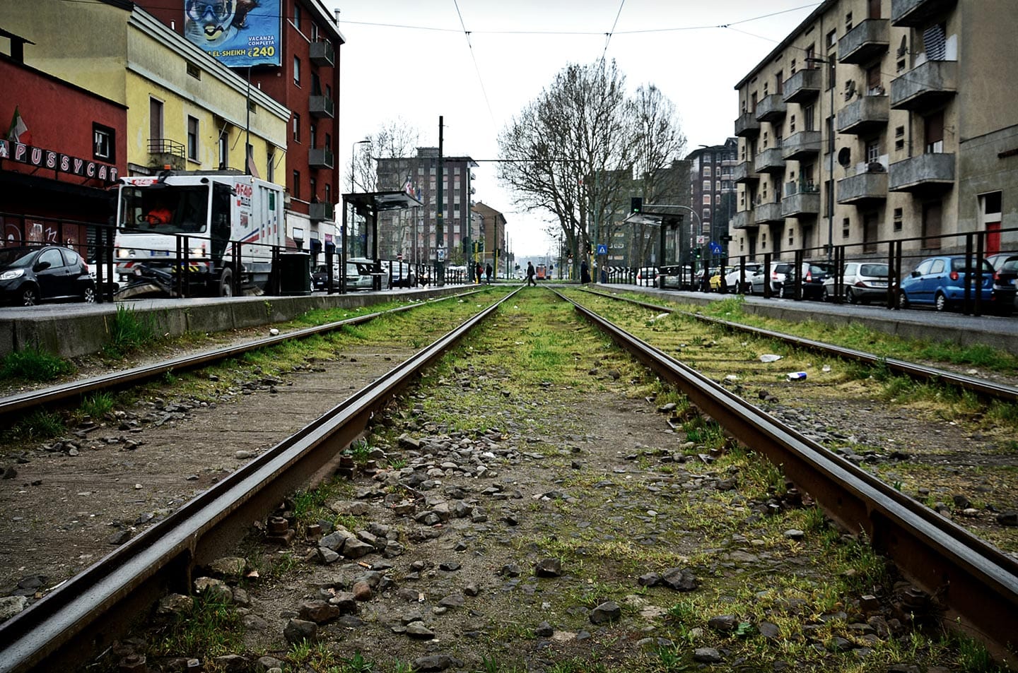 I binari del 14, che collegano il centro al Giambellino-Lorenteggio. In questo quartiere è evidente una suddivisione in modo gerarchico: “prima ci sono le case degli "sciuri" (tuttora Silvio Berlusconi si reca a votare nella scuola di via Scrosati, non lontana da via Odazio), poi quelle degli operai, quindi le casette del Villaggio dei Fiori, e infine il "blocco" di via Lorenteggio, le case dei reietti di Milano, spinte ai margini della città.”