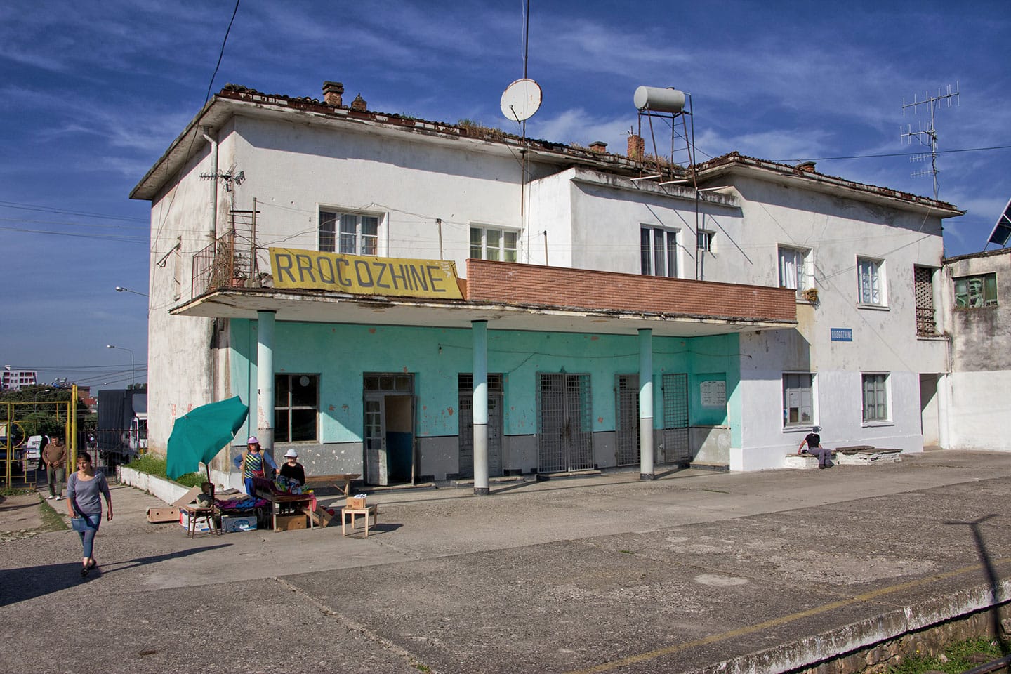 Sui marciapiedi della stazione di Rrogozhine, la capostazione allestisce una bancarella per arrotondare uno stipendio non certo milionario.