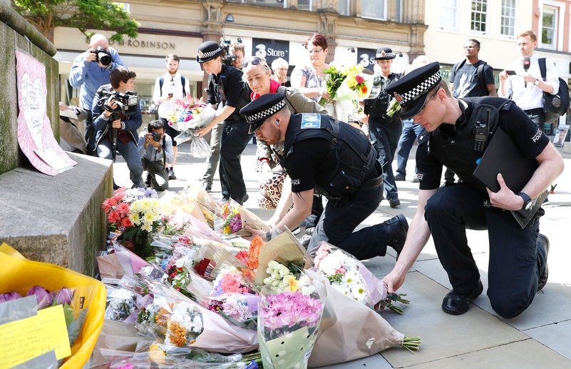 Poliziotti depongono fiori per le vittime dell’attacco terroristico alla Manchester Arena / Foto via Twitter
