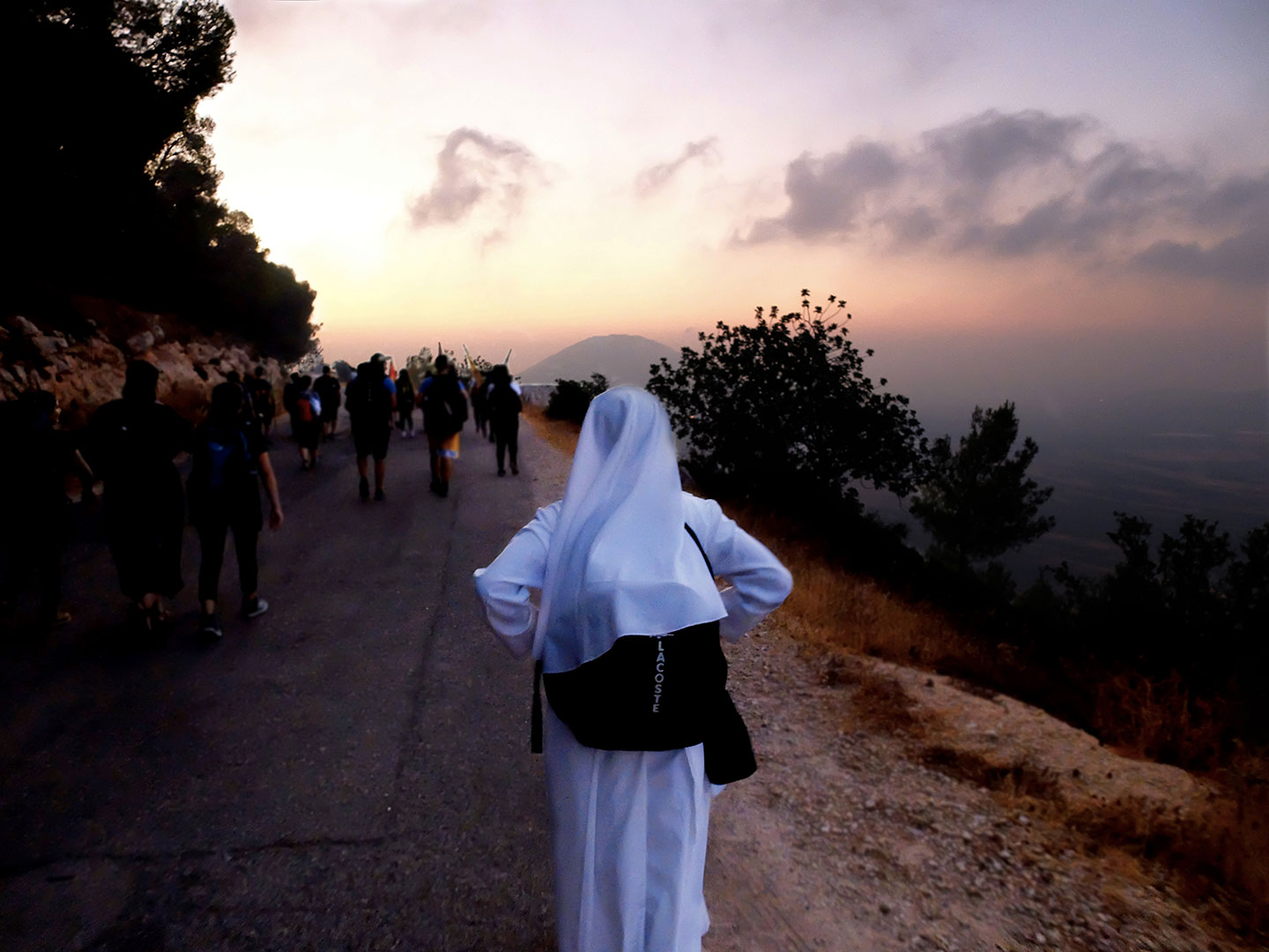 Una suora guarda l’orizzonte all’alba durante la Marcia Francescana lungo il cammino verso il Monte Tabor